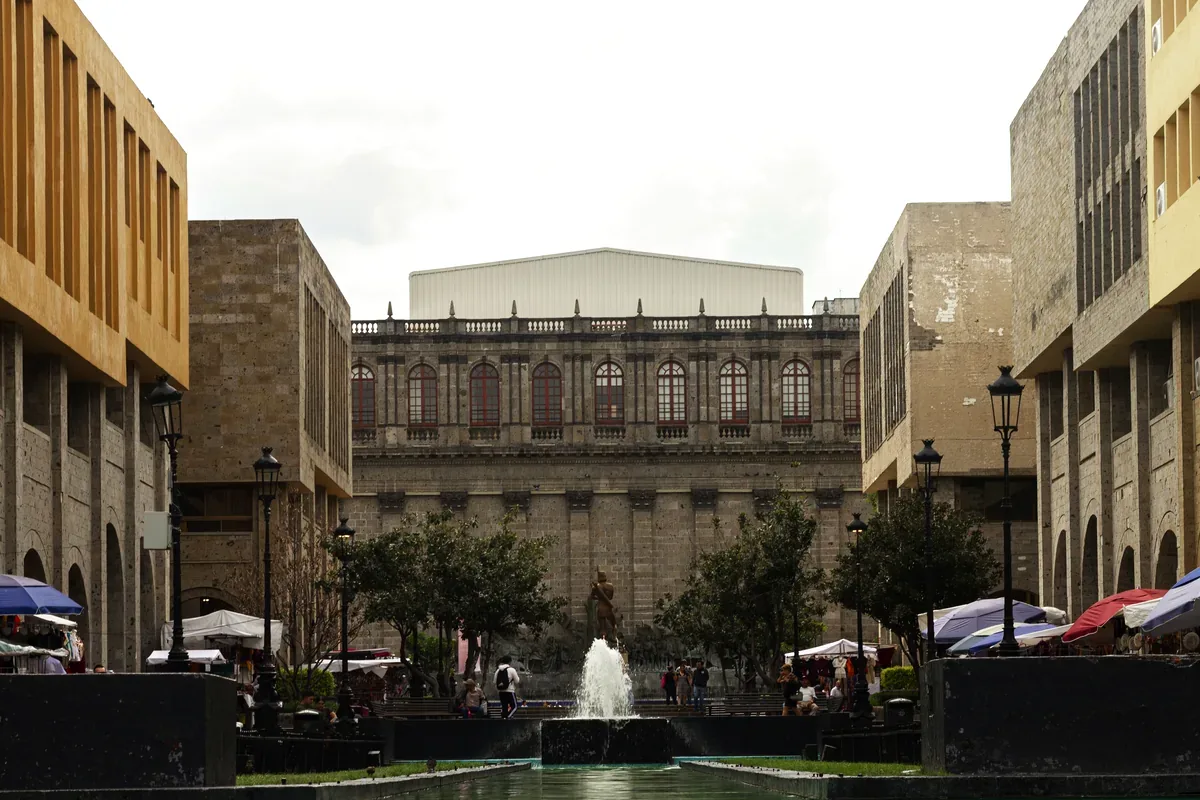 Plaza con una fuente frente a un edificio de cantera de estilo colonial