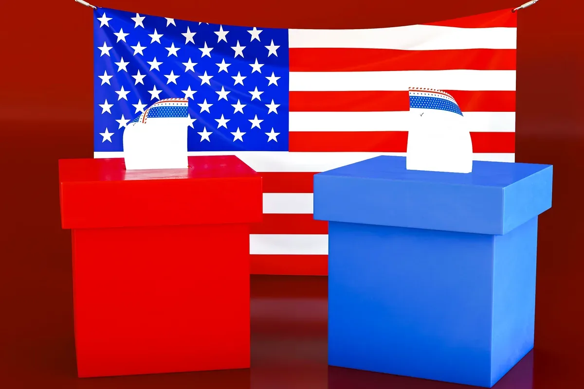 Dos urnas electorales, una roja y una azul, delante de una bandera de Estados Unidos