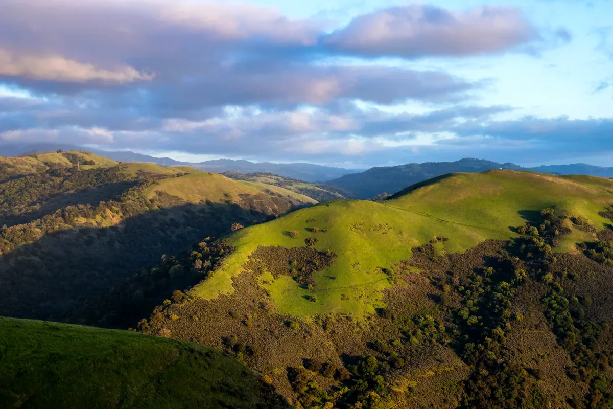 Colinas verdes y montañas al atardecer