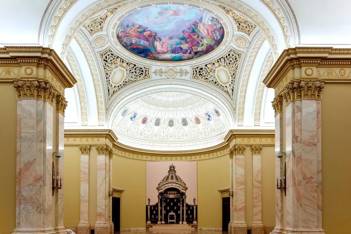 Sala de un museo con columnas de mármol y una cúpula pintada