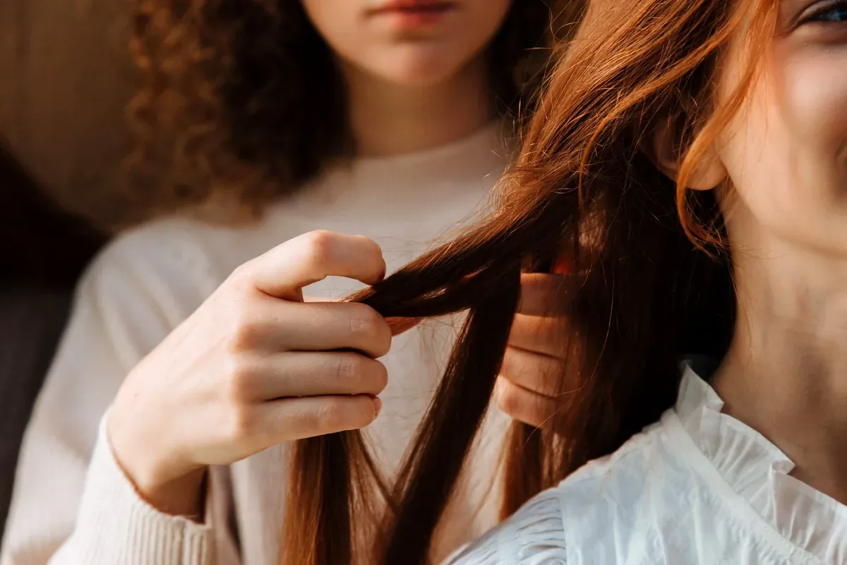 Manos que separan mechones de cabello largo