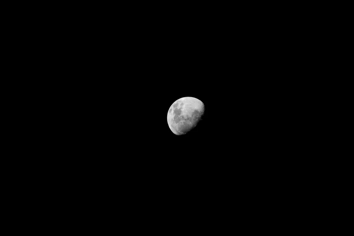 Luna en cuarto creciente sobre un cielo negro
