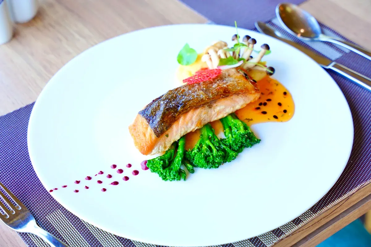 Salmón a la plancha con brócoli servido en un plato blanco