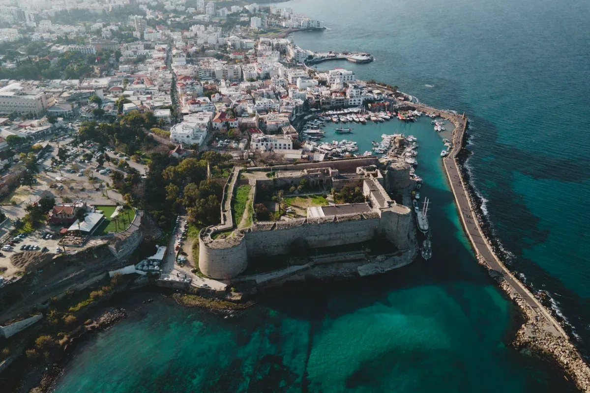 Vista aérea de una ciudad costera con un puerto y una fortaleza junto al mar