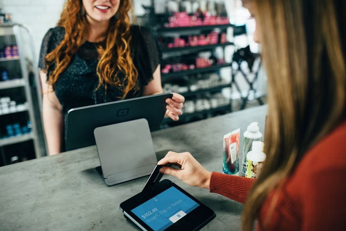 Clienta paga con tarjeta en el datáfono de una tienda
